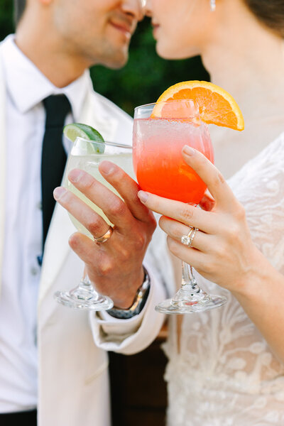 bride and groom kissing in front of beer cart