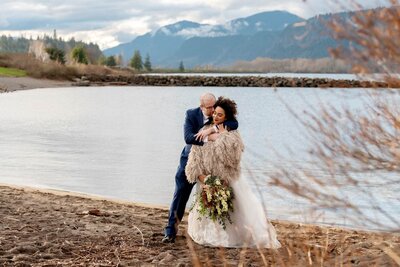 stylish bride and groom have intimate moment by columbia river gorge