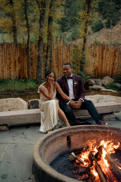 Couple sitting near fireplace at their wedding.