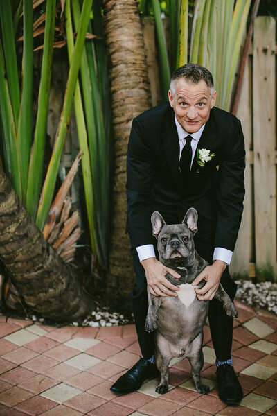 Groom posing with his Frenchie on Wedding Day