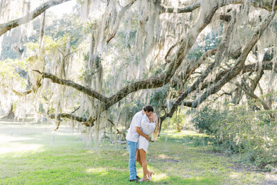 Couple kissing underneath the oak tree at Magnolia Plantation and gardens