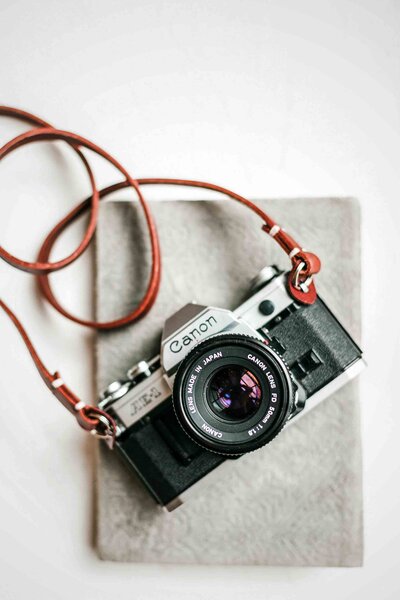 Vintage-canon-film-camera-on-tan-leather-neck-strap