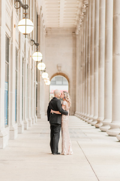 couple hugging in columned walkway