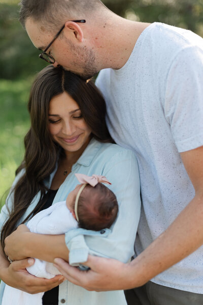 mom and dad looking down at baby