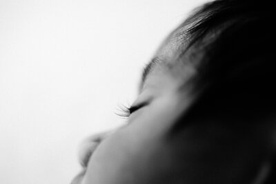A close up of a newborn babies eyelashes during a newborn photoshoot