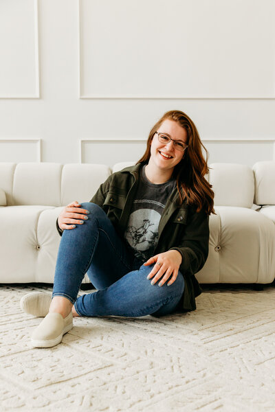 photo of woman sitting on the floor in front of a couch