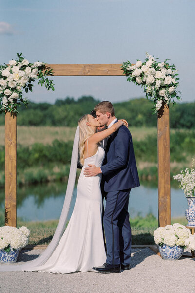 bride and groom kissing at an outdoor wedding ceremony