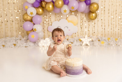 baby eating cake in studio by PHILADELPHIA NEWBORN PHOTOGRAPHER