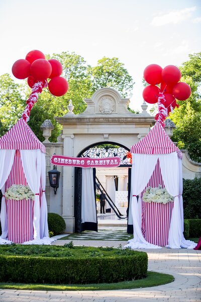Carnival party entrance with red balloons and oversized popcorn decorations