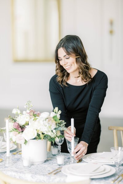 wedding planner in simple black shirt places candlestick