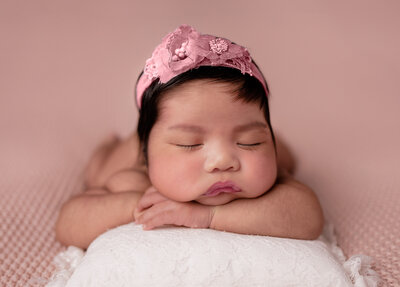 baby girl sleeping wearing a pink headband
