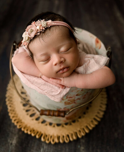Newborn portrait of a baby girl in a bucket