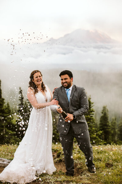 couple shakes champagne on Mt. Rainier