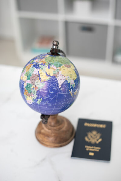 Globe and passport on white counter