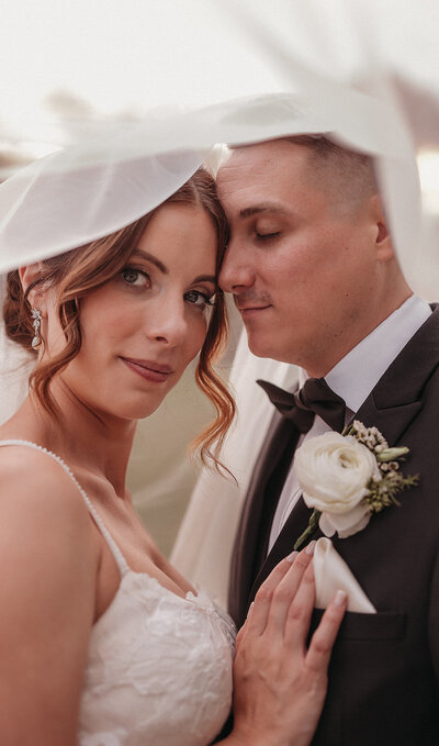 Documentary style NJ wedding photography of bride and groom under veil
