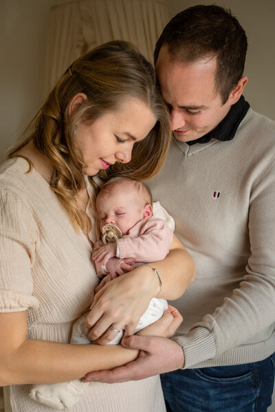 gezinsfoto met newborn zachte kleuren in huis