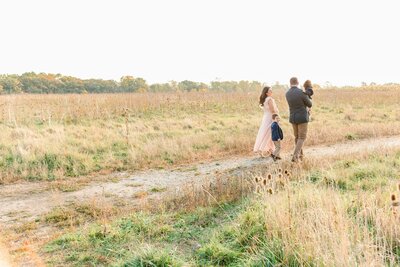 Family of 5 walking though a sunlit meadow by Chicago Family Photographer Kristen Hazelton