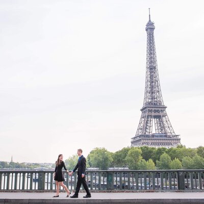 Getting engaged under the Eiffel Tower. Man and woman walk through streets of Paris.