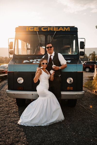 The Goldfish Barn wedding photos in Chambersburg, PA. Couple posing in front of ice cream truck on wedding day.