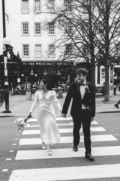 married couple walking hand and hand on street