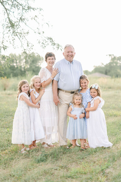 grandparents posing with granddaughters at extended family photoshoot in cedar falls iowa