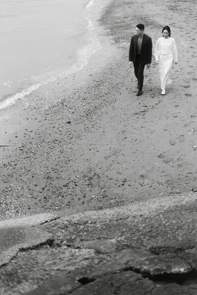 engaged couple holding hands while walking on the beach during a pre wedding shoot in Vancouver