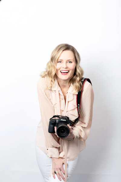 Photography Alison McWhirter holding camera and looking happy