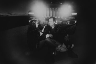 couple sits in front of headlights