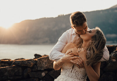 Bride and groom holding each other and kissing at the Griffin house with a view of the Columbia River Gorge