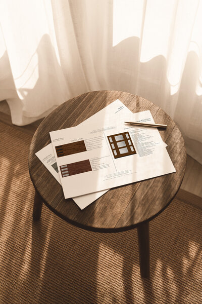 print out of exterior design plants on a wood stool in front of a window