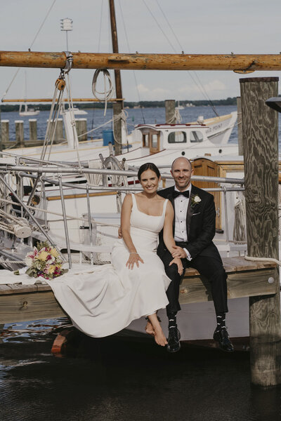 Bride and groom sitting together on a dock in Maryland