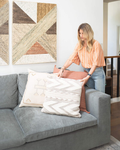 Interior designer staging a pillow on a couch