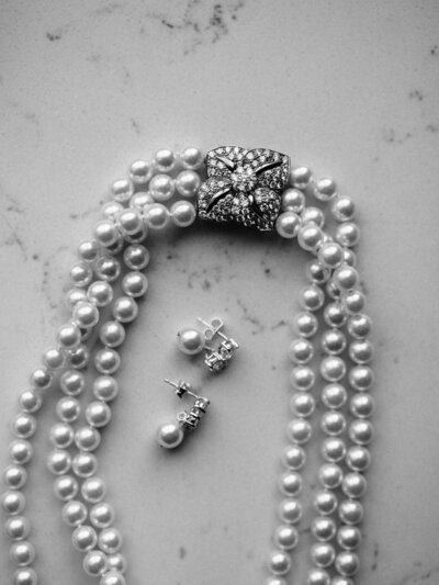 Black and white close-up photo of the bride’s necklace and earrings during a Tampa wedding.
