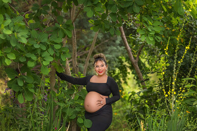 Pretty momma to be posing in skin tight maternity session at a creek.