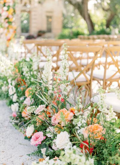 lush florals line ceremony aisle for luxury wedding