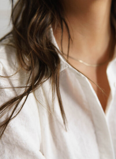 Close up of a silver necklace that a woman is wearing. Showing that counseling for women can be tailored to postpartum depression or anxiety. A Manhattan therapist for moms can help get you feeling better.