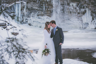 Snowy hiking elopement among a waterfall.