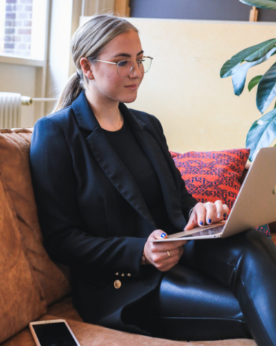 Woman in a black blazer working on a laptop