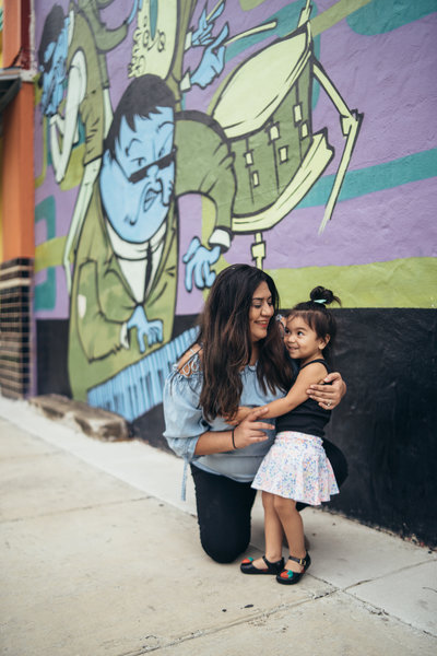 Photo of San Antonio Wedding Photographer Irene Castillo holding her daughter while posing for a picture