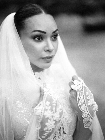 Beautiful bride in lace wedding gown wearing veil