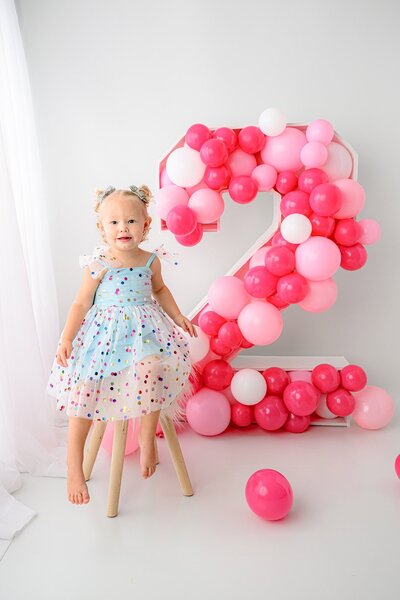 portrait of little girl in a blue confetti dress during her birthday photos