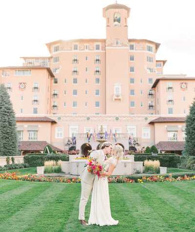 A couple kiss in front of the iconic Broadmoor Hotel in Colorado Springs, Colorado.