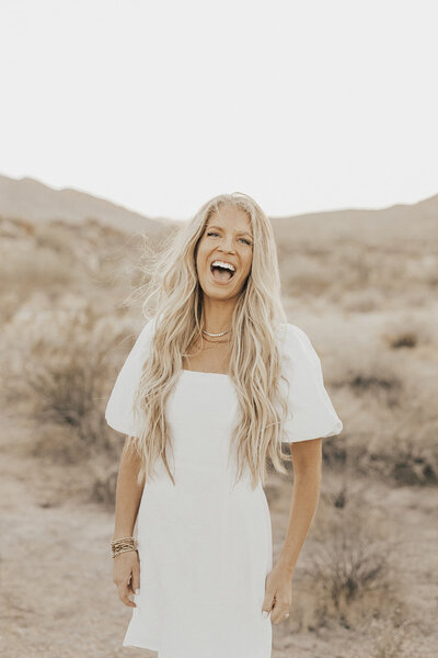 woman smiling and laughing in the desert