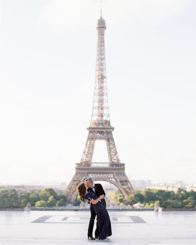 Husband dips wife while dancing in front of Eiffel Tower