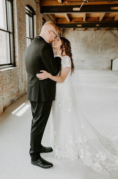 Bride + Groom slip on each others wedding rings after their ceremony