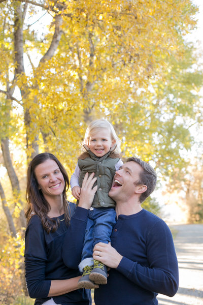 Husband, wife and daughter posing during a photoshoot in a local Denver park.