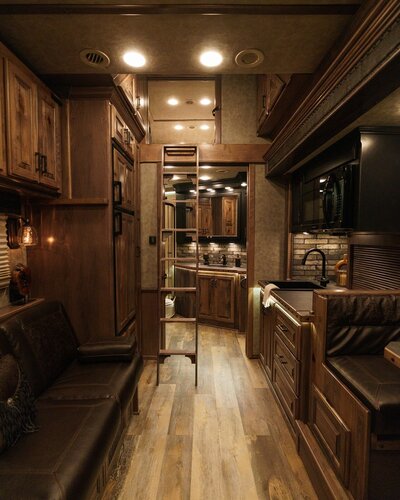 View into the bathroom and ladder to the loft inside a luxury horse trailer