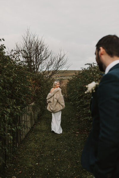 bride looks back over shoulders at groom