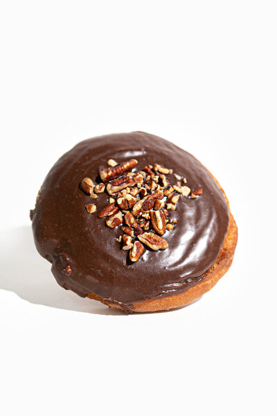 Chocolate Donut with Nuts on White Background - Daylight Donuts