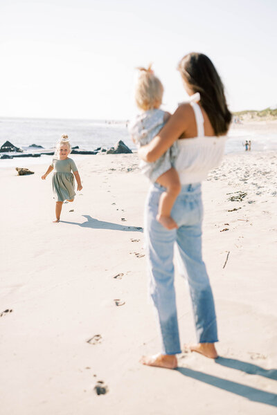 Mom holds her daughter as the second daughter runs toward her at the Pennsylvania shore